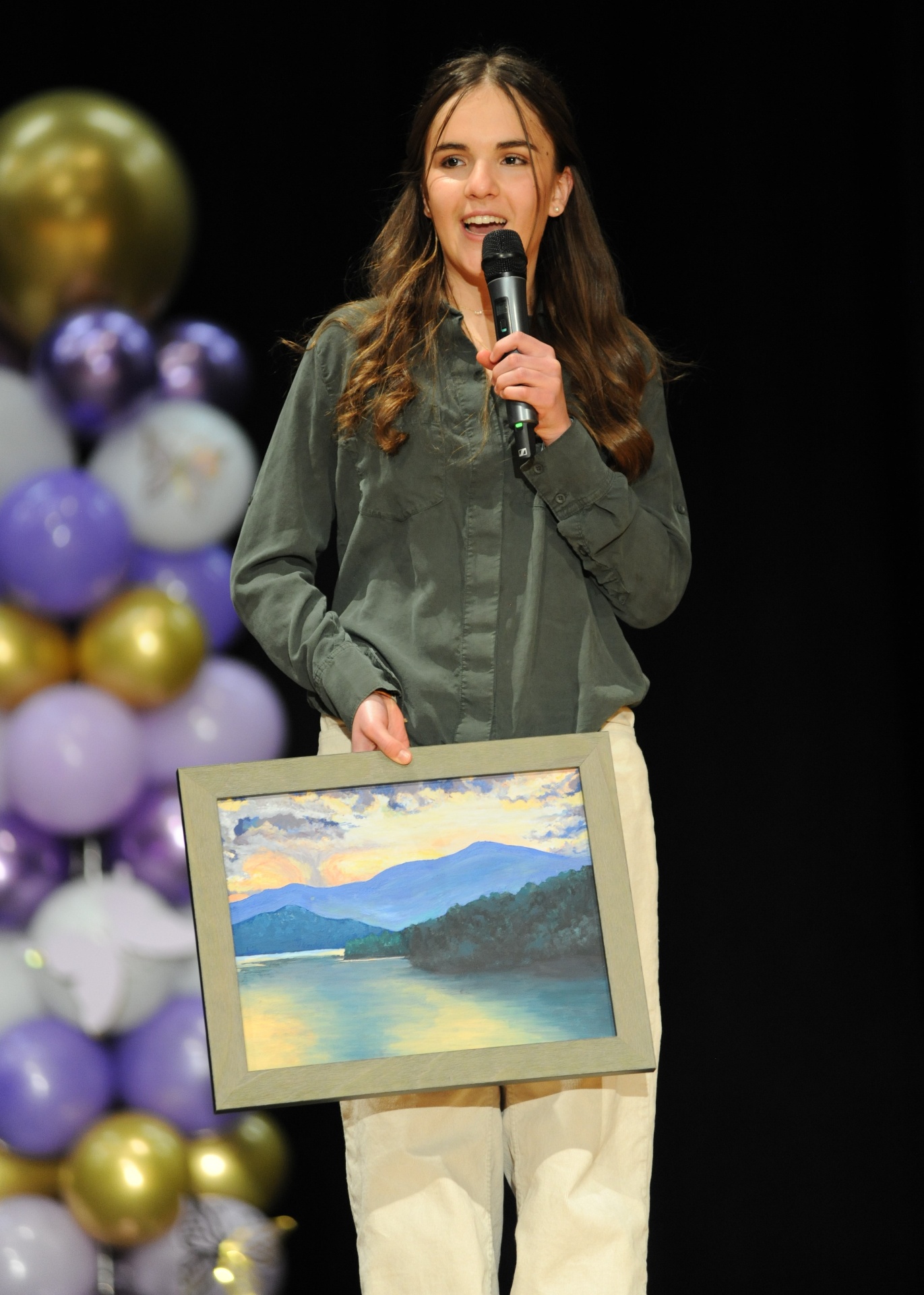 Visual arts student showcasing a landscape painting
